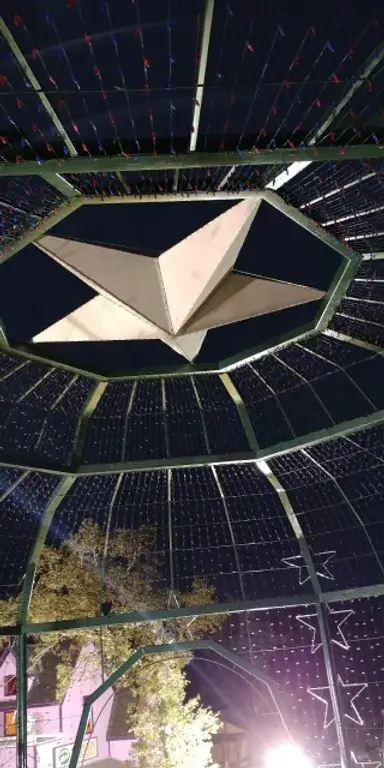 a large fabricatedmetal star on the top of an outdoor gazebo